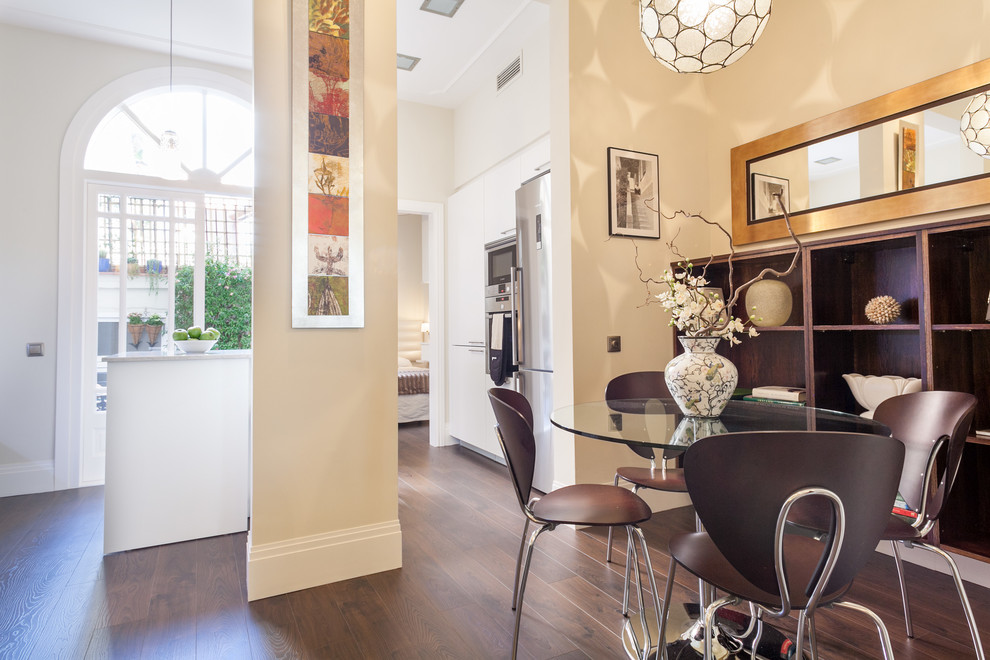 Modelo de comedor de cocina tradicional renovado pequeño sin chimenea con paredes beige y suelo de madera oscura