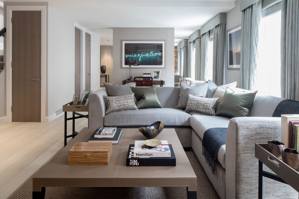 Photo of a transitional formal open concept living room in London with grey walls and light hardwood floors.
