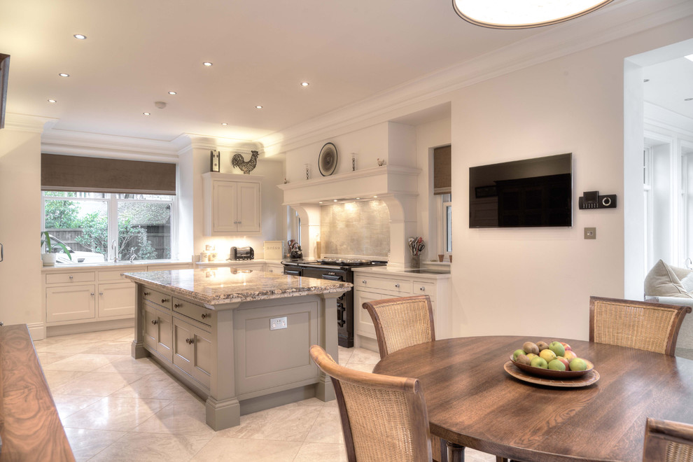 Photo of a large traditional u-shaped eat-in kitchen in Cheshire with a drop-in sink, shaker cabinets, white cabinets, granite benchtops, white splashback, glass sheet splashback, black appliances, travertine floors, with island and multi-coloured floor.