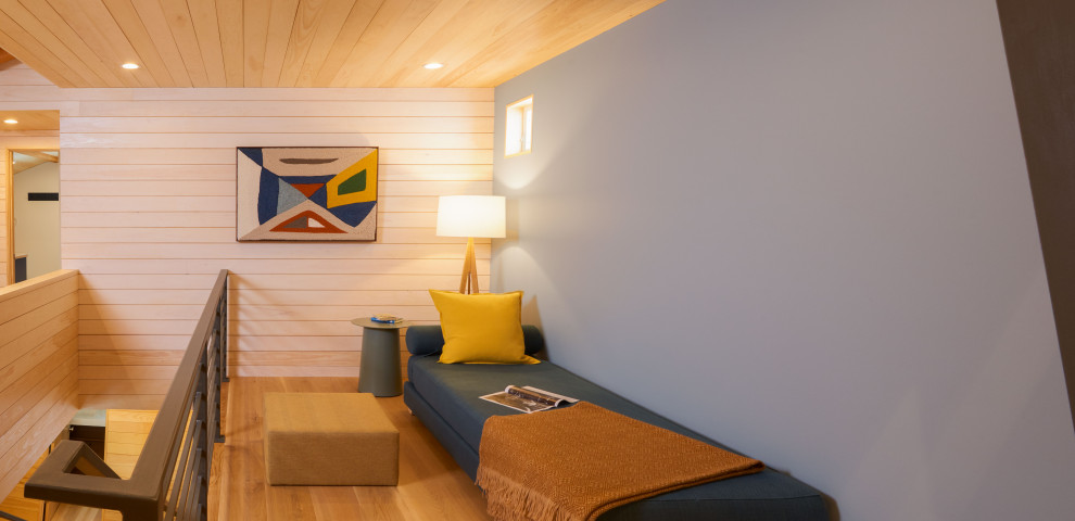 Cette photo montre un petit salon montagne en bois ouvert avec un mur bleu et un plafond en bois.