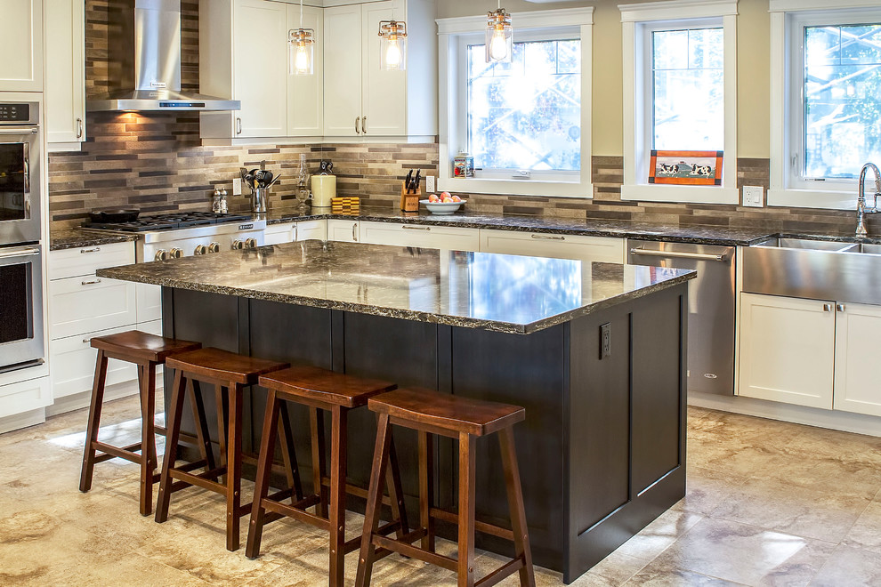 Large transitional l-shaped eat-in kitchen photo with a farmhouse sink, shaker cabinets, white cabinets, quartz countertops, brown backsplash, stone tile backsplash, stainless steel appliances and an island