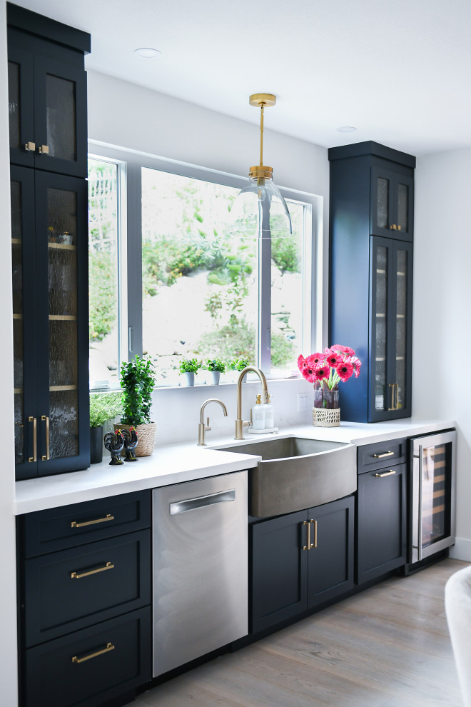 Example of a large tuscan medium tone wood floor and brown floor kitchen design in San Diego with a farmhouse sink, shaker cabinets, light wood cabinets, quartz countertops, blue backsplash, terra-cotta backsplash, paneled appliances, an island and white countertops