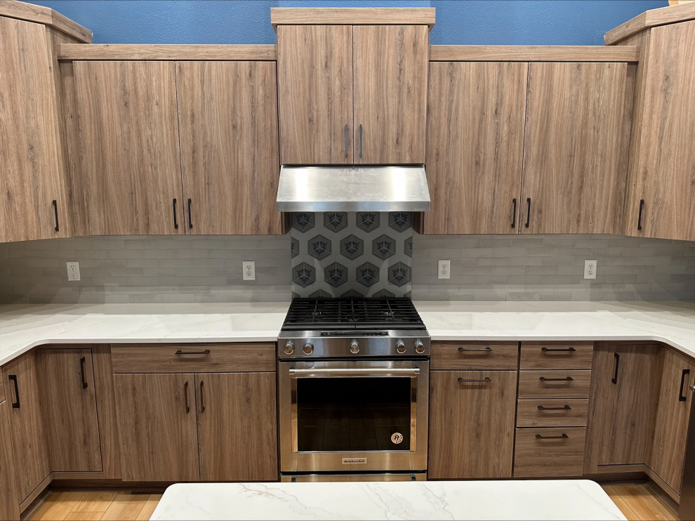 Example of a mid-sized transitional u-shaped eat-in kitchen design with quartz countertops and an island