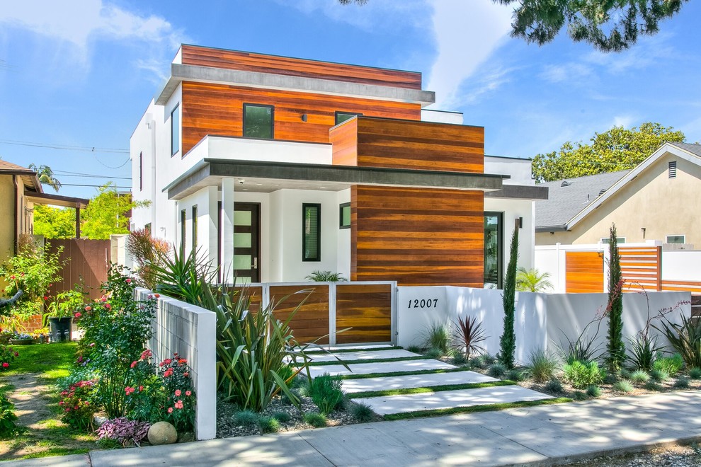 Photo of a mid-sized contemporary two-storey white house exterior in Orange County with mixed siding, a flat roof and a metal roof.