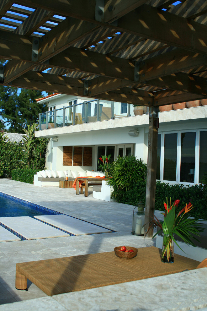 Photo of a mid-sized tropical backyard patio in Miami with an outdoor kitchen, tile and a pergola.