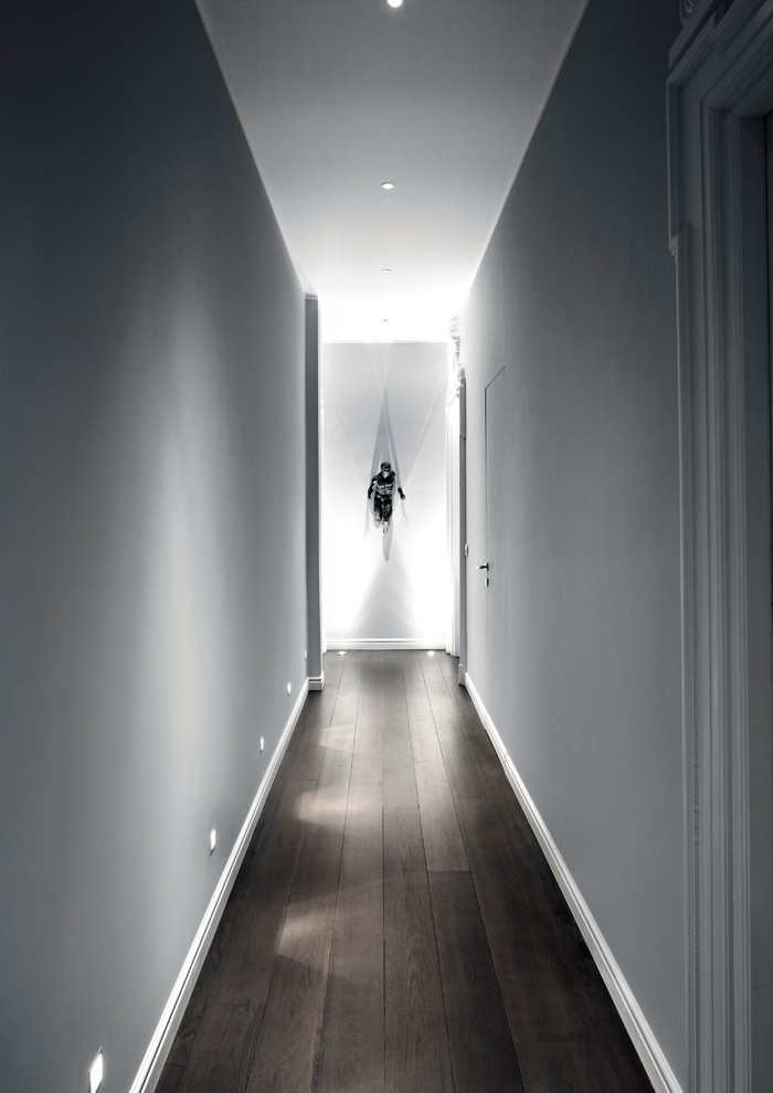 This is an example of a contemporary hallway in Milan with grey walls and dark hardwood floors.