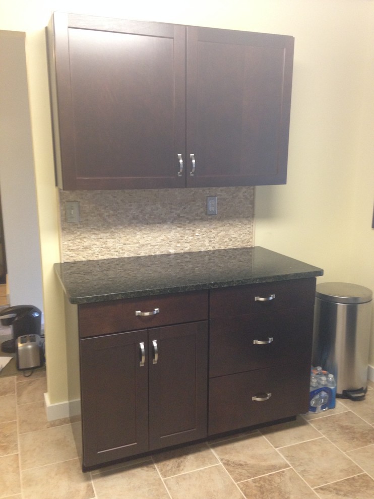 Example of a mid-sized transitional l-shaped porcelain tile enclosed kitchen design with an undermount sink, shaker cabinets, dark wood cabinets, granite countertops, beige backsplash, stone tile backsplash, stainless steel appliances and an island