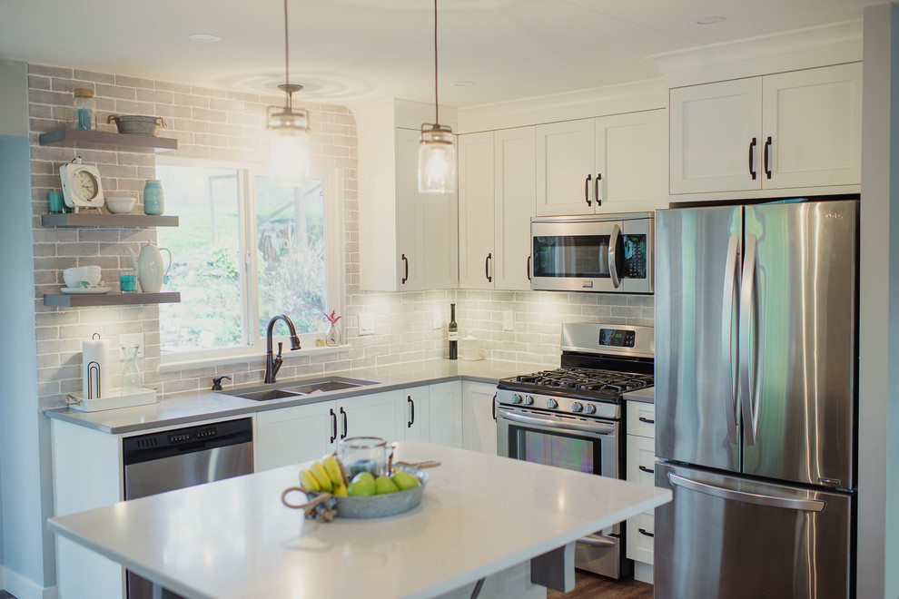Mid-sized transitional l-shaped eat-in kitchen photo in Vancouver with an undermount sink, shaker cabinets, white cabinets, quartz countertops, gray backsplash, stainless steel appliances, an island, porcelain backsplash and white countertops