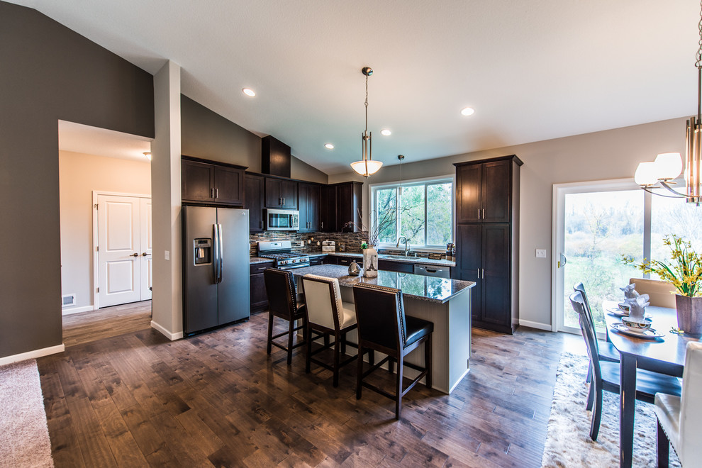 Eat-in kitchen - mid-sized transitional l-shaped dark wood floor and brown floor eat-in kitchen idea in Minneapolis with an undermount sink, shaker cabinets, dark wood cabinets, granite countertops, multicolored backsplash, matchstick tile backsplash, stainless steel appliances and an island