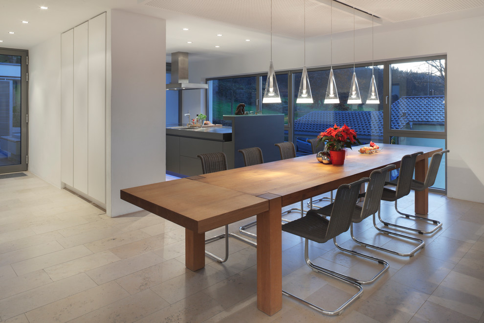 Mid-sized contemporary open plan dining in Frankfurt with white walls and travertine floors.