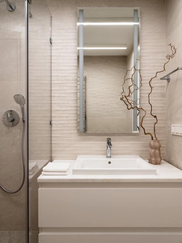 Modern inredning av ett mellanstort vit vitt badrum med dusch, med släta luckor, vita skåp, en dusch i en alkov, en vägghängd toalettstol, beige kakel, porslinskakel, beige väggar, klinkergolv i porslin, ett nedsänkt handfat, marmorbänkskiva, beiget golv och dusch med duschdraperi