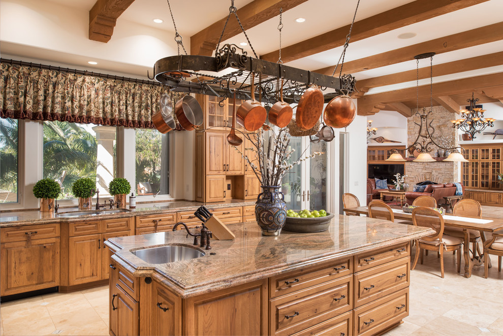 Design ideas for a mediterranean open plan kitchen in San Diego with an undermount sink, raised-panel cabinets, medium wood cabinets, with island and beige floor.