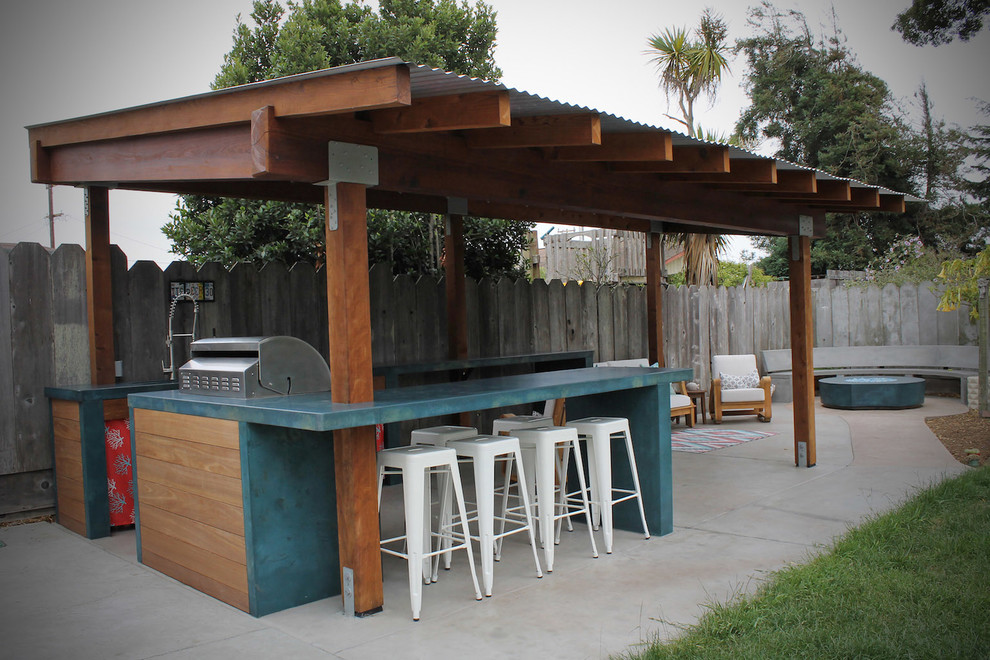 Photo of a large beach style backyard patio with an outdoor kitchen, concrete slab and a gazebo/cabana.
