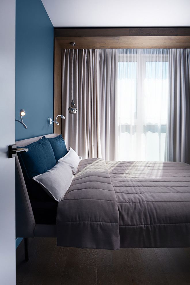 Idéer för att renovera ett skandinaviskt sovrum, med blå väggar och mellanmörkt trägolv