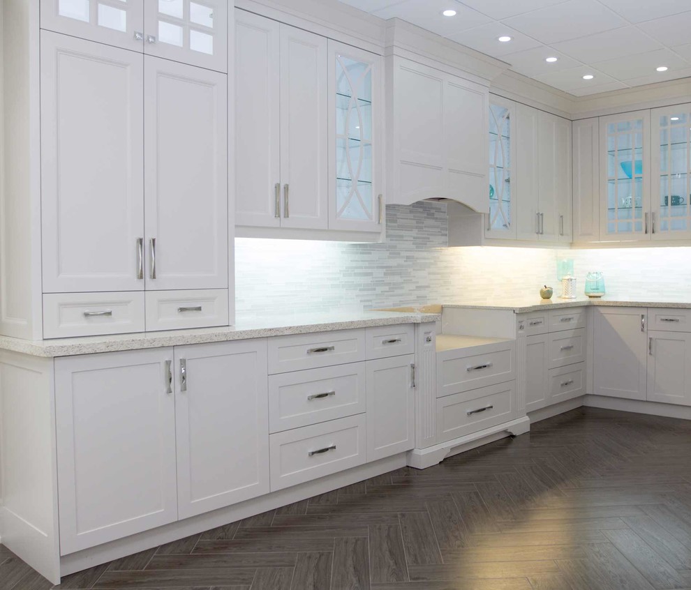 This is an example of a large contemporary l-shaped open plan kitchen in Toronto with shaker cabinets, grey splashback, brown floor, white cabinets, granite benchtops and matchstick tile splashback.