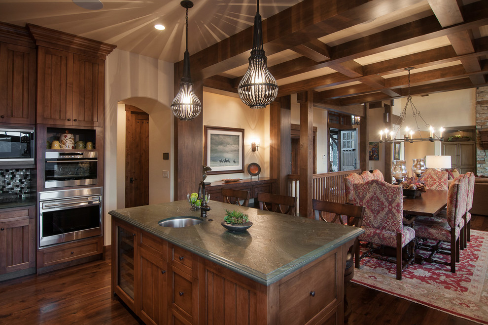 Photo of a country eat-in kitchen in Salt Lake City with a single-bowl sink, recessed-panel cabinets, dark wood cabinets, stainless steel appliances and green benchtop.