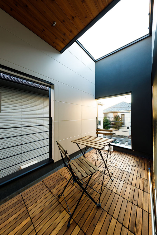 Photo of a mid-sized industrial balcony in Tokyo Suburbs with with privacy feature, no cover and metal railing.