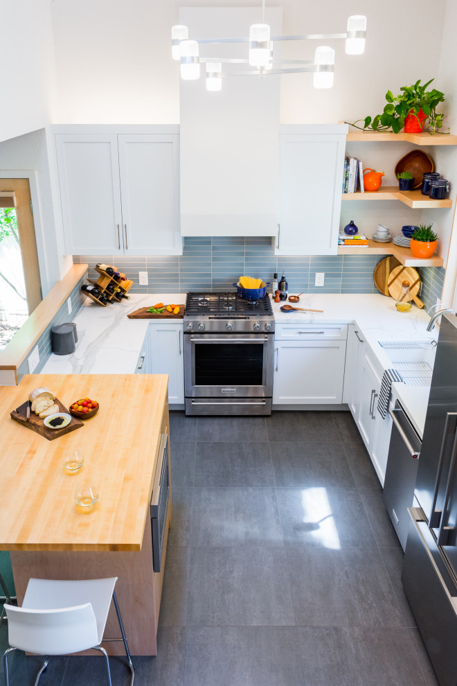 Small contemporary u-shaped eat-in kitchen in Sacramento with recessed-panel cabinets, white cabinets, quartz benchtops, blue splashback, ceramic splashback, stainless steel appliances, a peninsula, white benchtop, a single-bowl sink, grey floor and vaulted.
