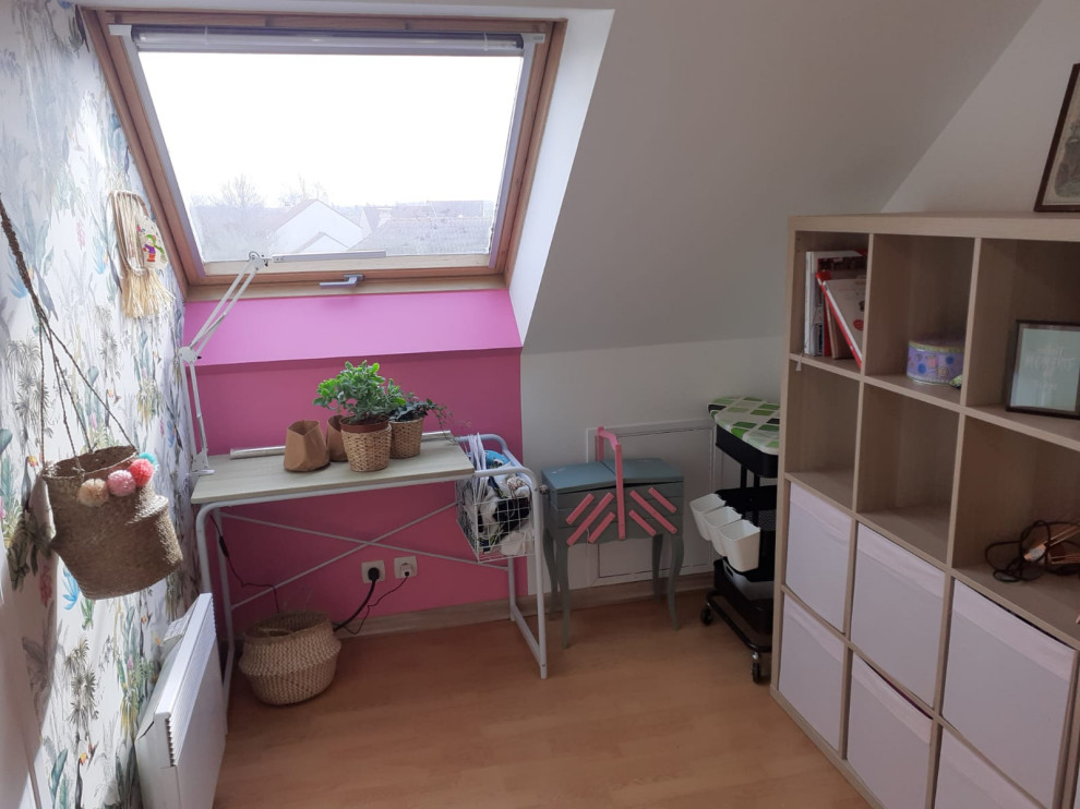 Ejemplo de dormitorio infantil exótico de tamaño medio con paredes rosas, suelo de madera clara, papel pintado y escritorio