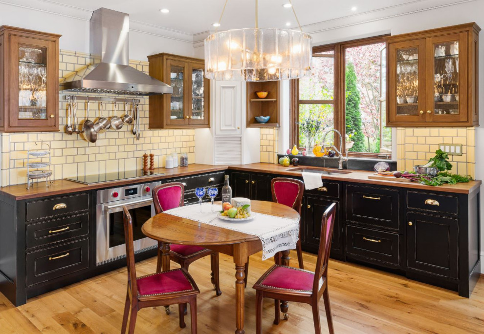 Photo of an eclectic kitchen in Philadelphia with wood worktops, yellow splashback, stainless steel appliances and no island.
