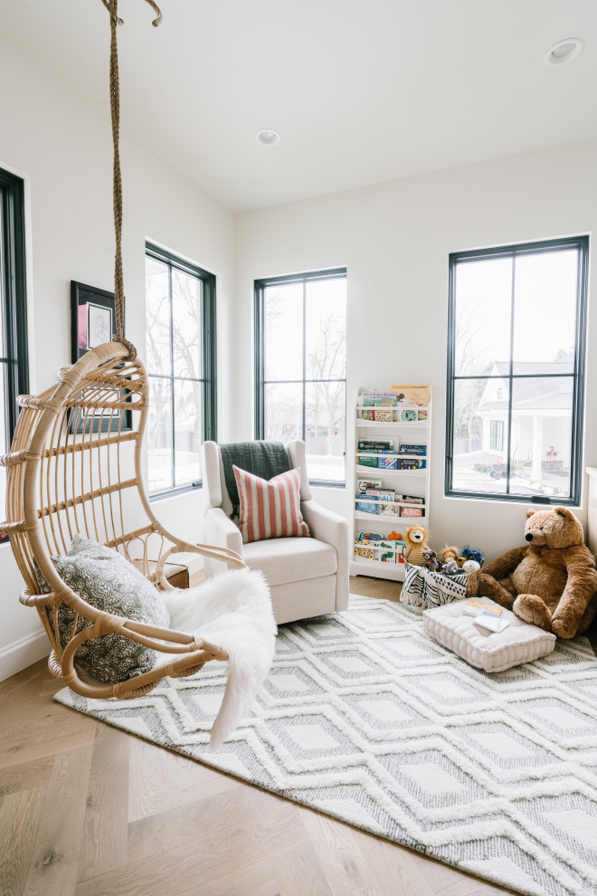 Cette image montre une chambre d'enfant de 1 à 3 ans traditionnelle de taille moyenne avec un mur blanc, parquet clair et un sol marron.