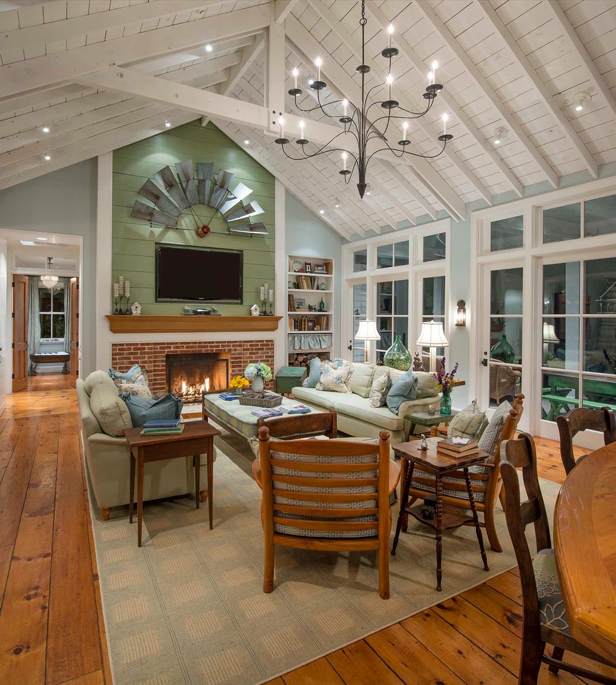 Design ideas for a country open concept living room in Dallas with grey walls, medium hardwood floors, a standard fireplace, a brick fireplace surround and a wall-mounted tv.