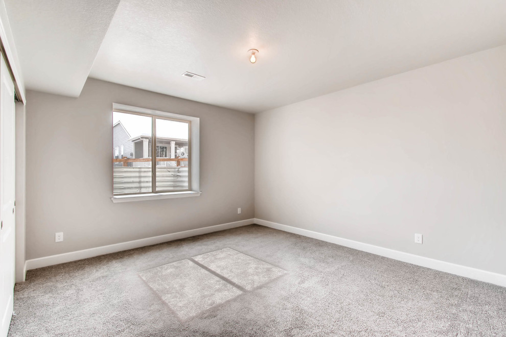 Inspiration for a large underground carpeted and gray floor basement remodel in Denver with gray walls and no fireplace