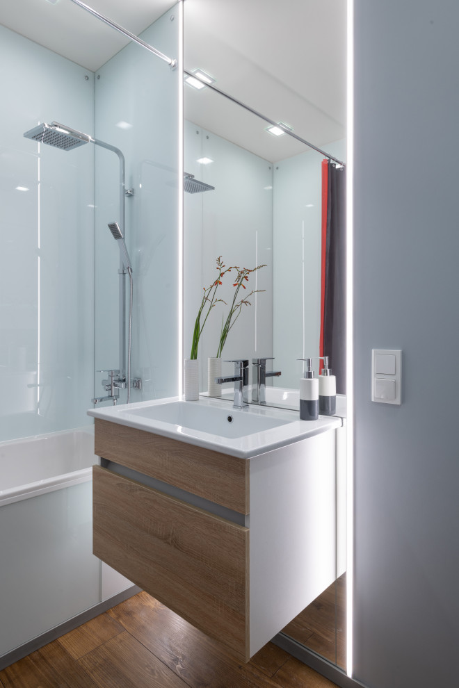 Inspiration for a medium sized contemporary ensuite bathroom in Yekaterinburg with flat-panel cabinets, medium wood cabinets, a submerged bath, a shower/bath combination, a wall mounted toilet, glass sheet walls, grey walls, porcelain flooring, a submerged sink, brown floors, a shower curtain, a single sink and a floating vanity unit.