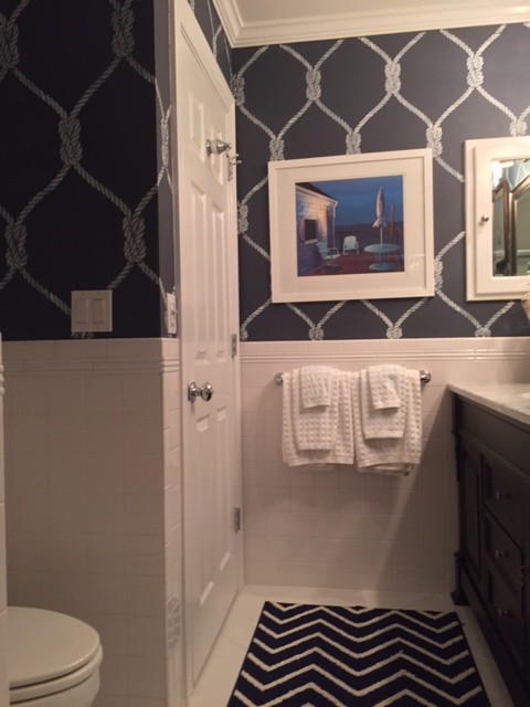 Photo of a small beach style master bathroom in New York with an undermount sink, dark wood cabinets, wood benchtops, an alcove tub, a shower/bathtub combo, a one-piece toilet, white tile, ceramic tile, grey walls, ceramic floors and recessed-panel cabinets.