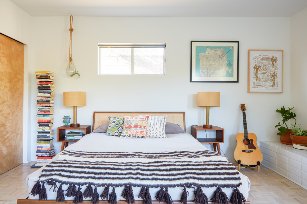This is an example of a midcentury bedroom in Los Angeles with white walls, light hardwood floors and beige floor.