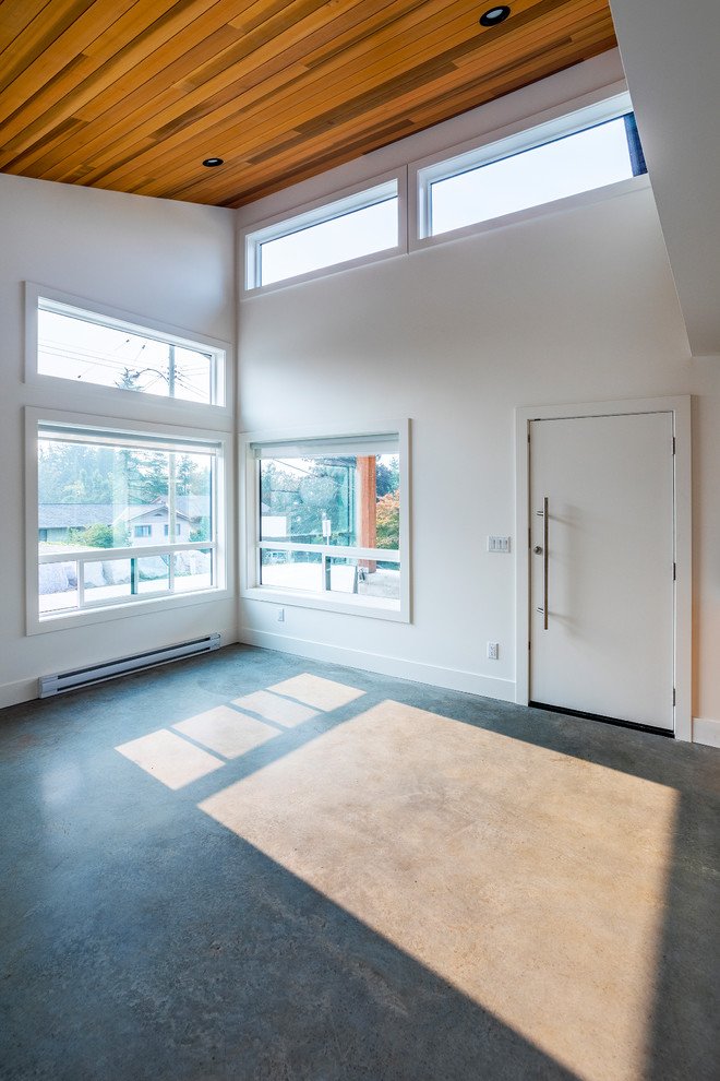 Esempio di un piccolo soggiorno minimal aperto con pareti bianche, pavimento in cemento, porta TV ad angolo e pavimento grigio