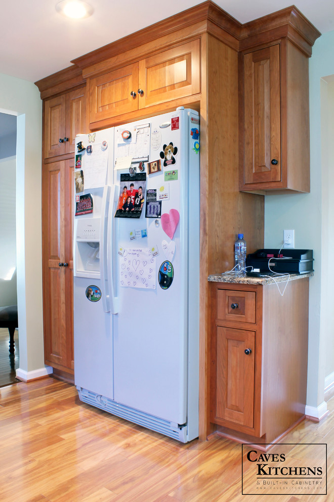 Mid-sized transitional u-shaped medium tone wood floor eat-in kitchen photo in New York with an undermount sink, beaded inset cabinets, medium tone wood cabinets, quartz countertops, multicolored backsplash, stone slab backsplash, white appliances, green walls and a peninsula