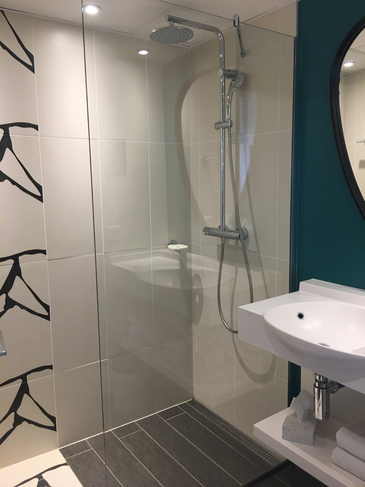 Idéer för att renovera ett mellanstort funkis vit vitt badrum med dusch, med en kantlös dusch, beige kakel, blå väggar, ett väggmonterat handfat och brunt golv