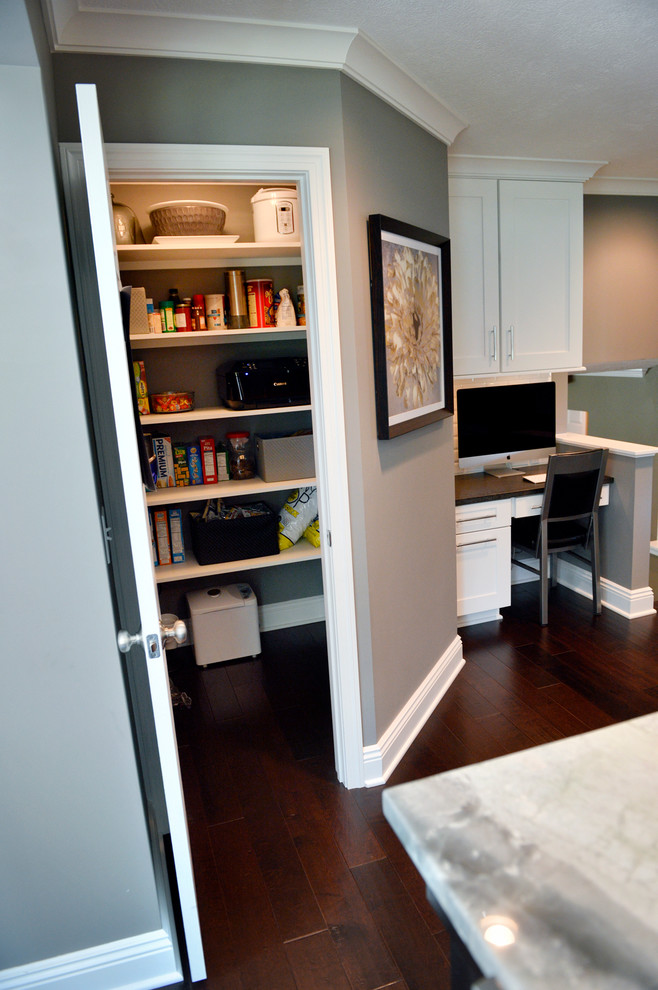 Inspiration for a transitional dark wood floor kitchen remodel in Cleveland with a drop-in sink, recessed-panel cabinets, white backsplash, ceramic backsplash, stainless steel appliances and an island
