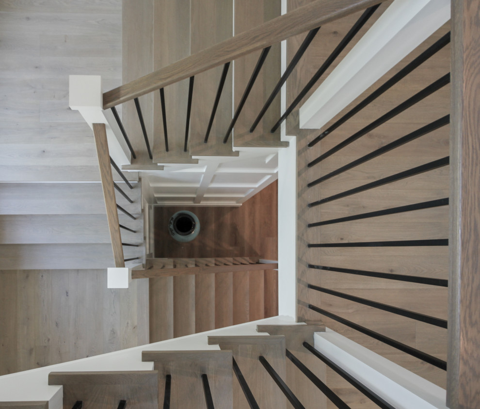 ワシントンD.C.にある高級な広いトランジショナルスタイルのおしゃれな階段 (木の蹴込み板、木材の手すり、羽目板の壁) の写真