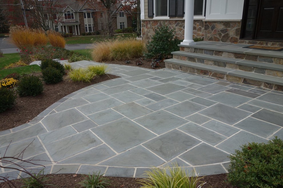 Photo of a large transitional courtyard patio in New York with natural stone pavers and no cover.