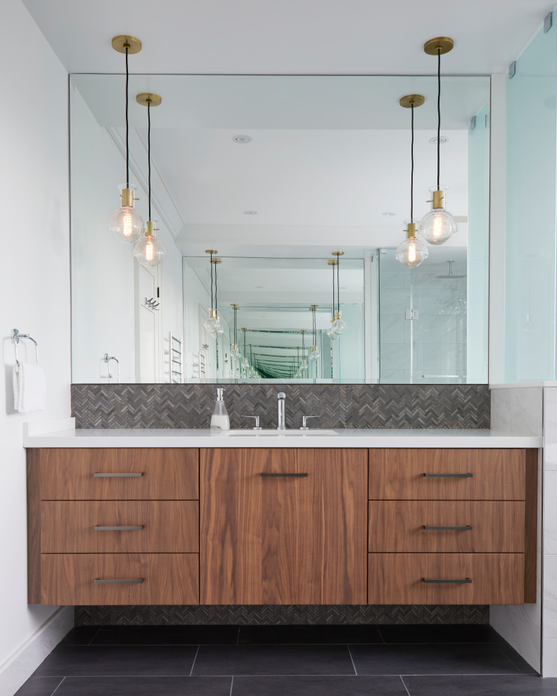 This is an example of a large contemporary master bathroom in Toronto with flat-panel cabinets, medium wood cabinets, a freestanding tub, an alcove shower, a two-piece toilet, white tile, porcelain tile, white walls, porcelain floors, an undermount sink, engineered quartz benchtops, black floor, an open shower, white benchtops, a double vanity and a floating vanity.