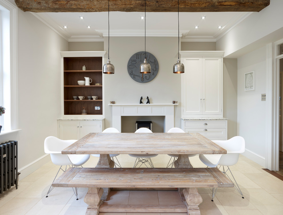 This is an example of a mid-sized traditional kitchen/dining combo in Hertfordshire with beige walls, ceramic floors, a standard fireplace and a plaster fireplace surround.