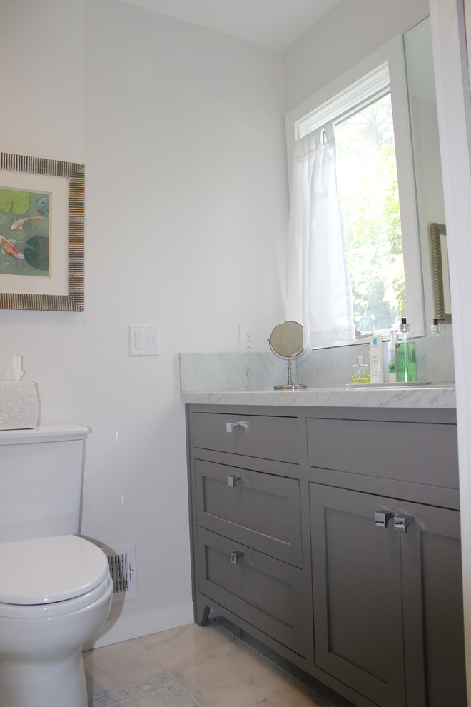 This is an example of a mid-sized transitional kids bathroom in San Francisco with an undermount sink, shaker cabinets, grey cabinets, a drop-in tub, an alcove shower, a one-piece toilet, white tile and white walls.