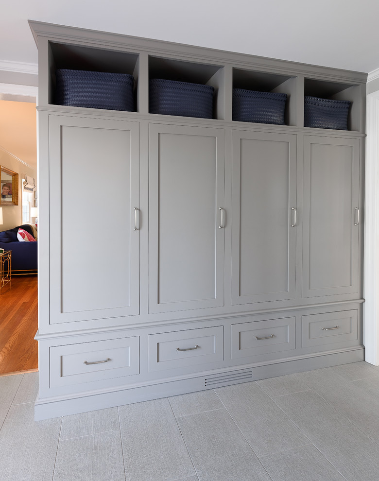 This is an example of a small transitional mudroom in New York with grey walls, porcelain floors, a single front door, a black front door and grey floor.