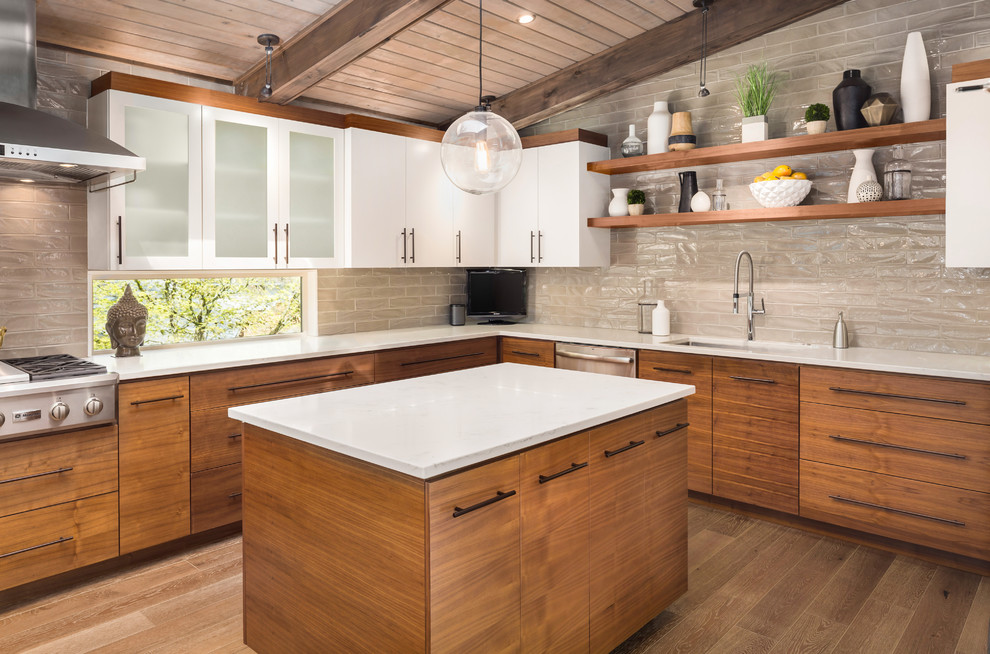 This is an example of a large midcentury l-shaped open plan kitchen in Portland with an undermount sink, flat-panel cabinets, light wood cabinets, quartzite benchtops, beige splashback, stainless steel appliances, light hardwood floors, with island and beige floor.