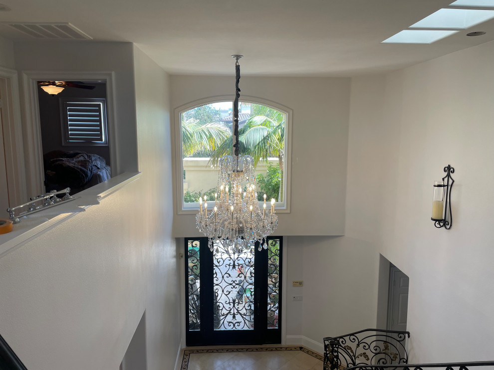 This is an example of a large traditional foyer in Orange County with white walls and a black front door.