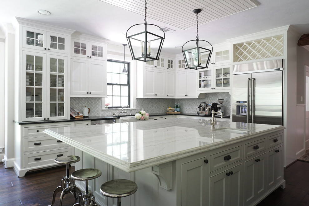 Inspiration for a country l-shaped kitchen in Houston with a farmhouse sink, beaded inset cabinets, white cabinets, soapstone benchtops, white splashback, marble splashback, stainless steel appliances, dark hardwood floors, with island, brown floor and black benchtop.