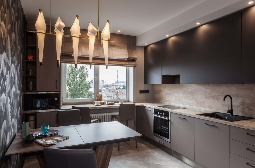Photo of a contemporary l-shaped eat-in kitchen in Saint Petersburg with a drop-in sink, flat-panel cabinets, black cabinets, beige splashback, stainless steel appliances, grey floor and beige benchtop.