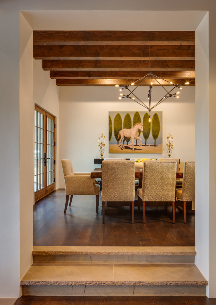 Exemple d'une salle à manger sud-ouest américain avec un mur beige, parquet foncé, un sol marron et poutres apparentes.