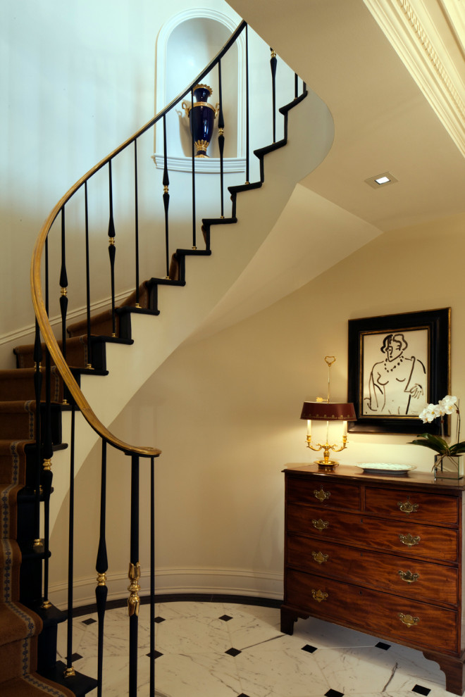 Photo of a classic painted wood curved metal railing staircase in Baltimore with painted wood risers.