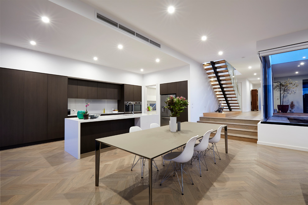 Design ideas for a contemporary kitchen/dining combo in Melbourne with white walls, light hardwood floors, no fireplace and beige floor.
