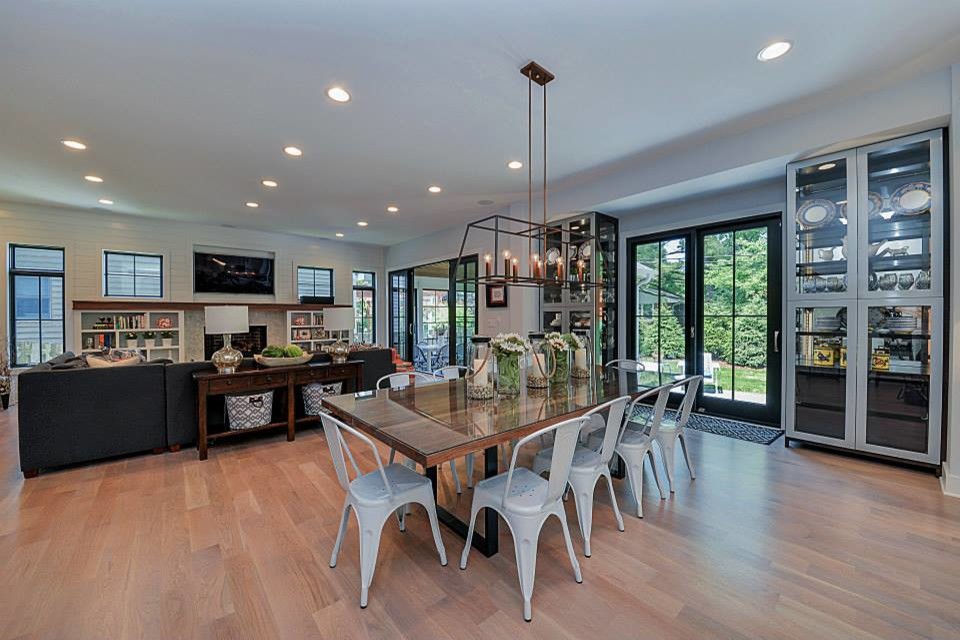 Inspiration for a mid-sized transitional u-shaped light wood floor eat-in kitchen remodel in Chicago with white cabinets, a farmhouse sink, recessed-panel cabinets, marble countertops, gray backsplash, mosaic tile backsplash, stainless steel appliances and an island