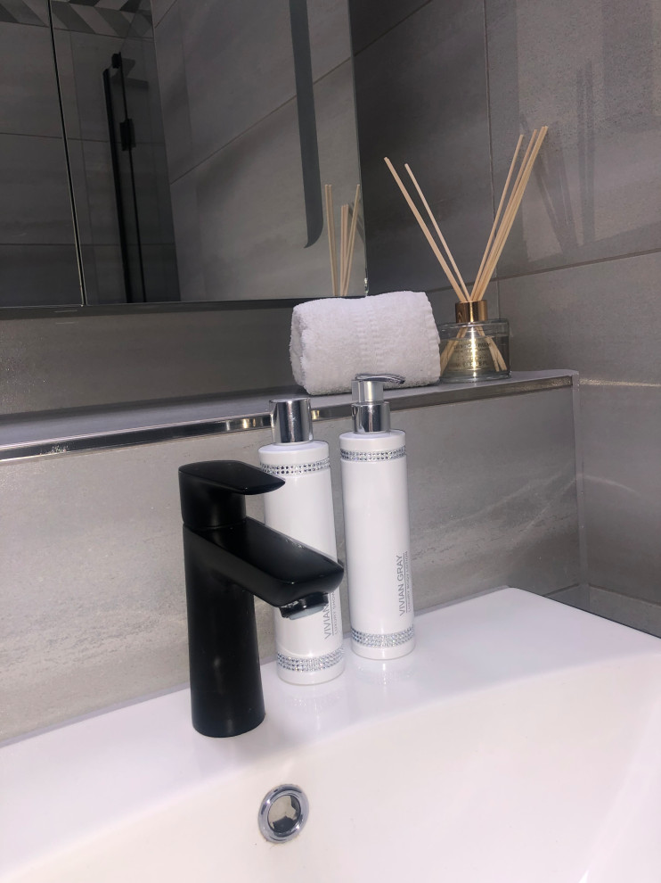 Exemple d'une salle de bain principale et grise et noire tendance en bois foncé de taille moyenne avec un placard à porte plane, une douche ouverte, un bidet, un carrelage gris, des carreaux de porcelaine, un mur blanc, un sol en carrelage de porcelaine, un lavabo intégré, un plan de toilette en carrelage, un sol noir, une cabine de douche à porte battante, un plan de toilette gris, un banc de douche, meuble simple vasque, meuble-lavabo sur pied et un plafond voûté.