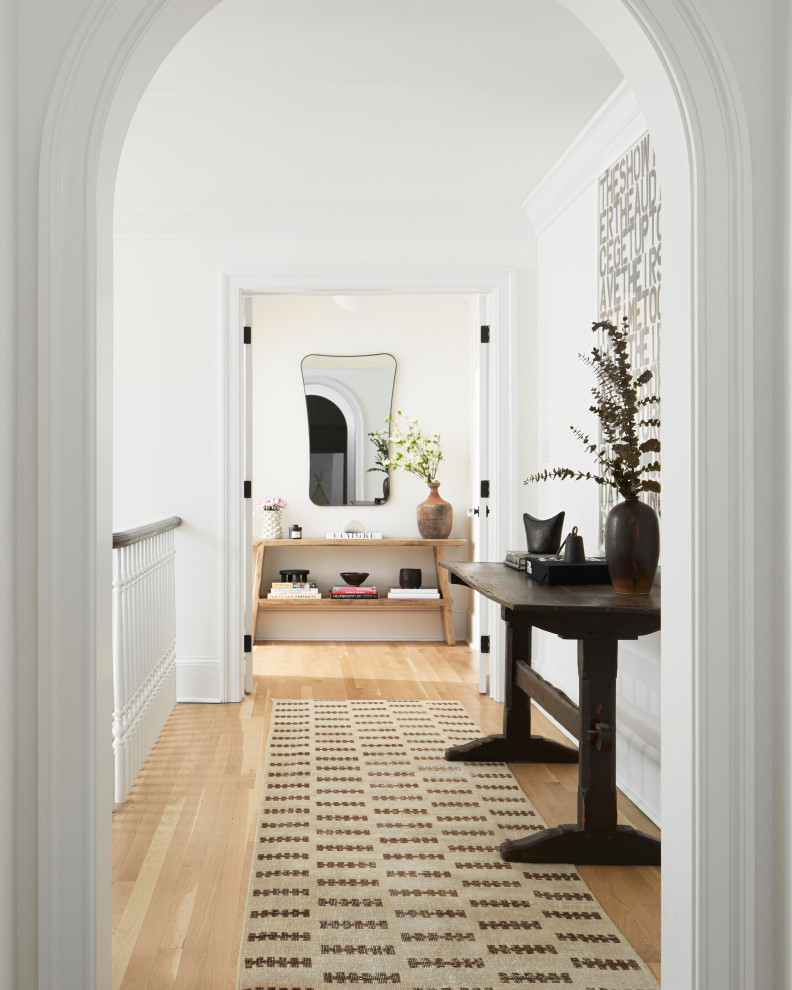 Photo of a scandinavian hallway in Philadelphia with white walls, light hardwood floors and beige floor.
